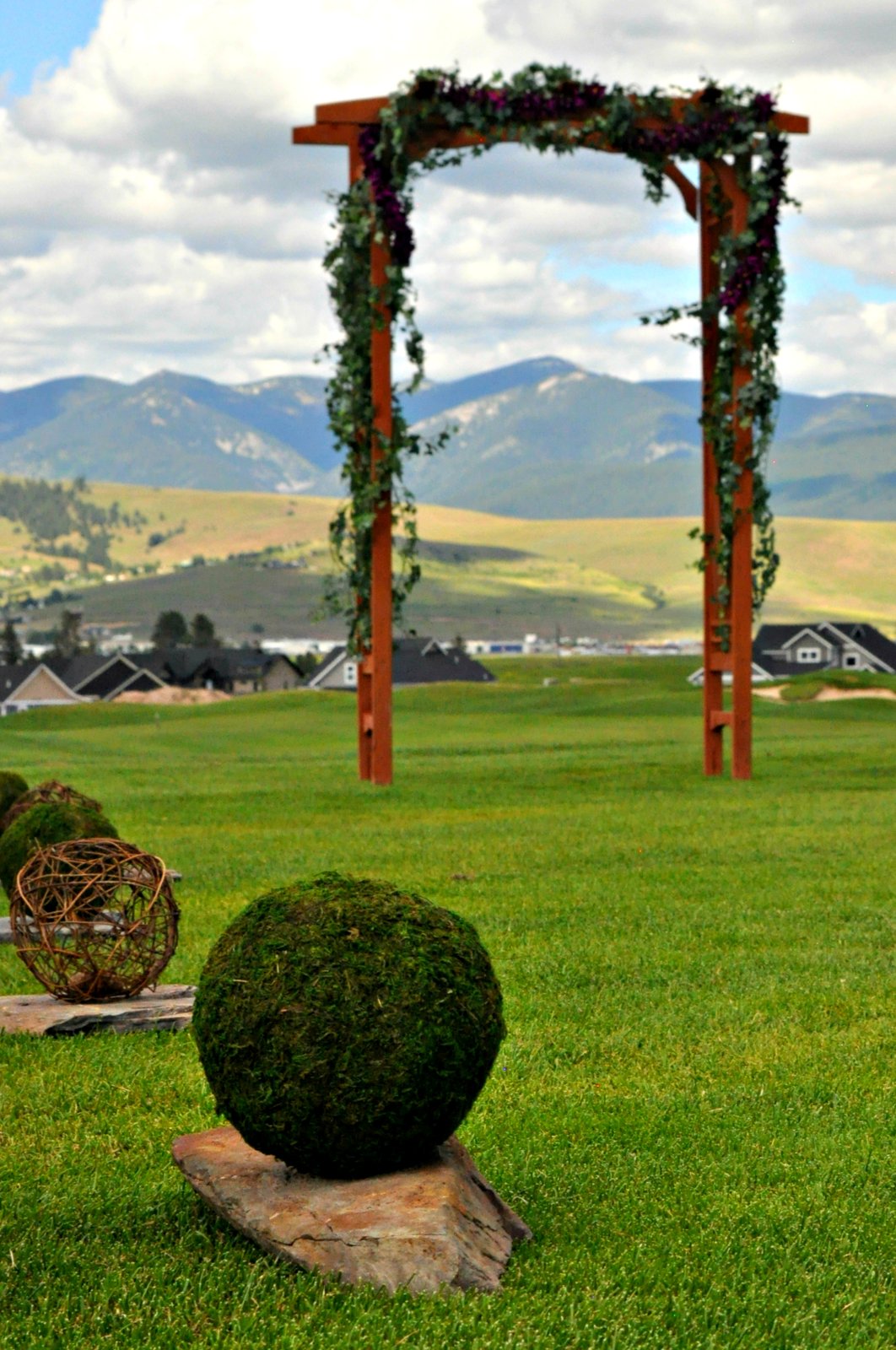 Wooden ceremony arch with mountain view and moss aisle markers